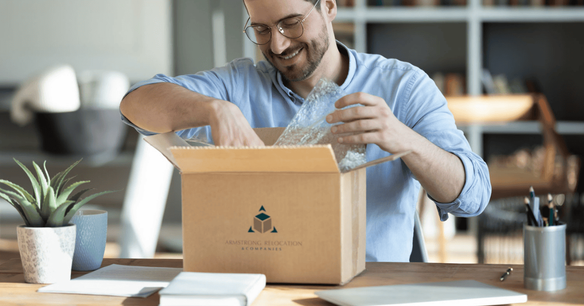 Man in glasses happily packing