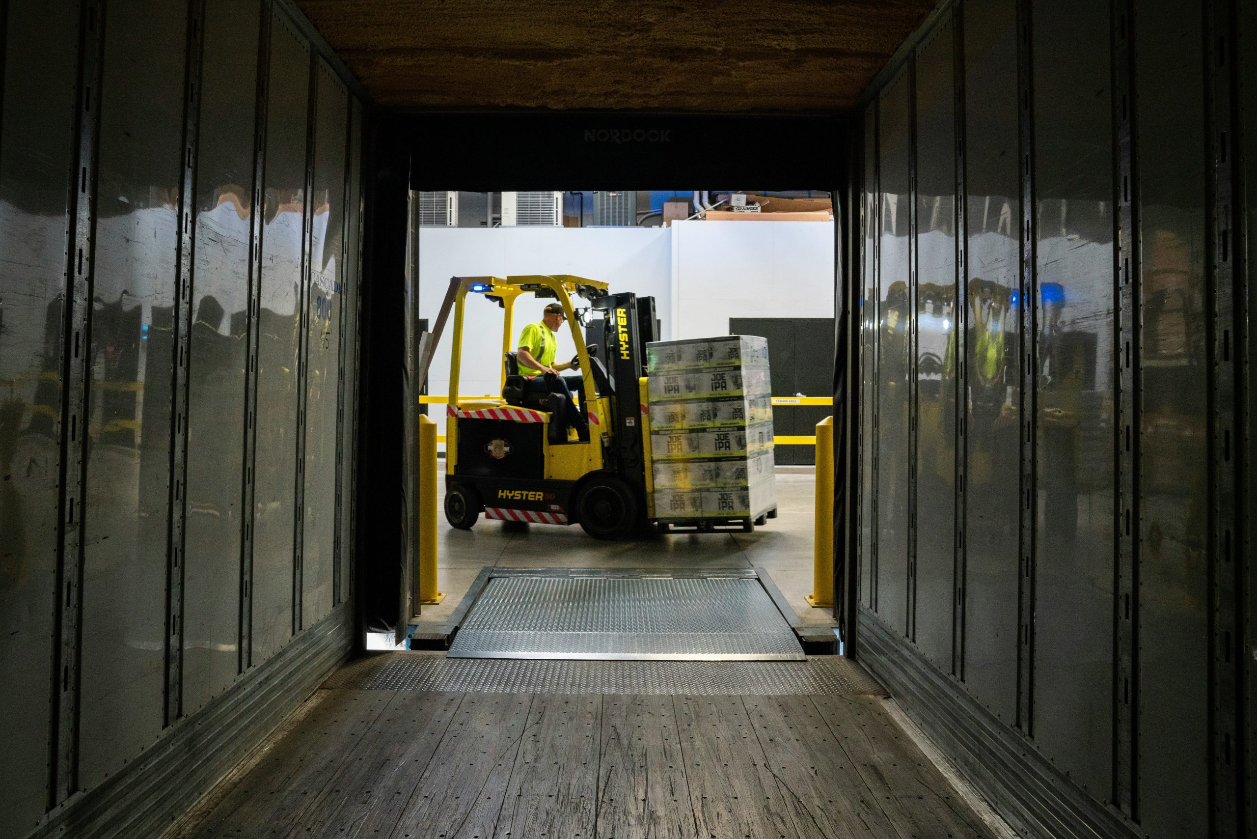 warehouse worker loading boxes into a truck as part of the less than truckload shipping process