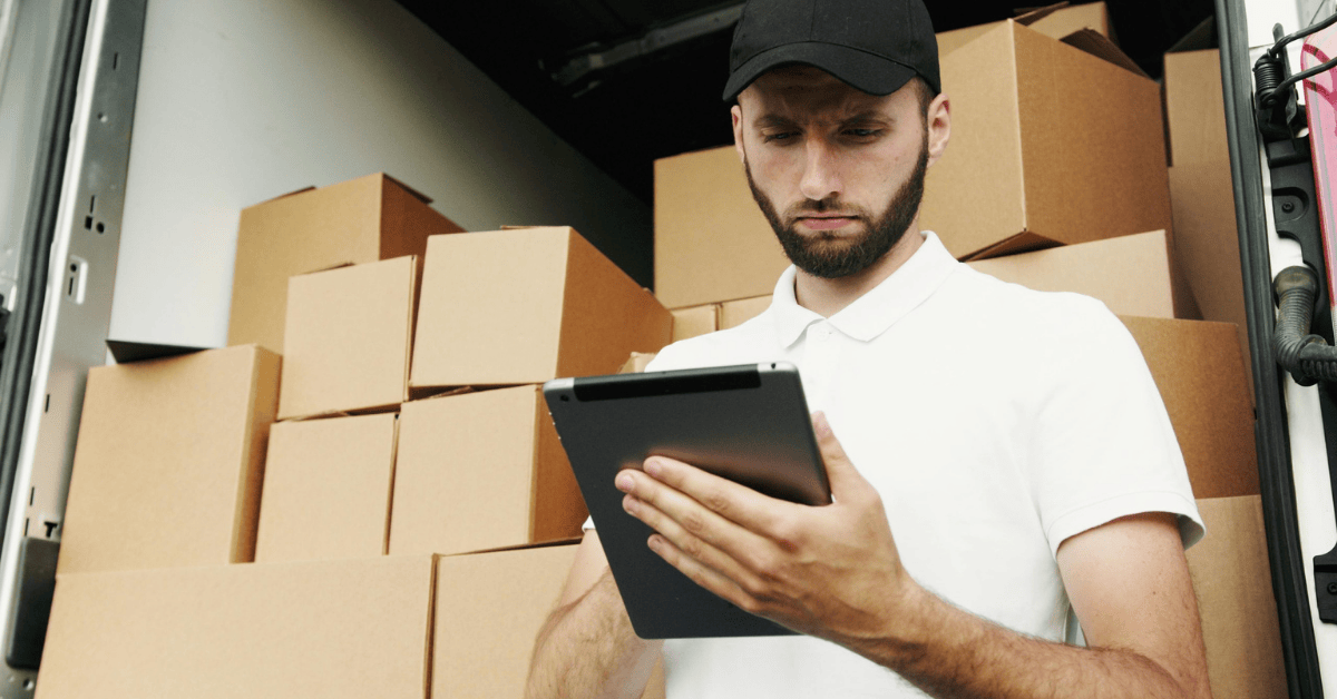 man doing checklist and loading a truck with moving boxes