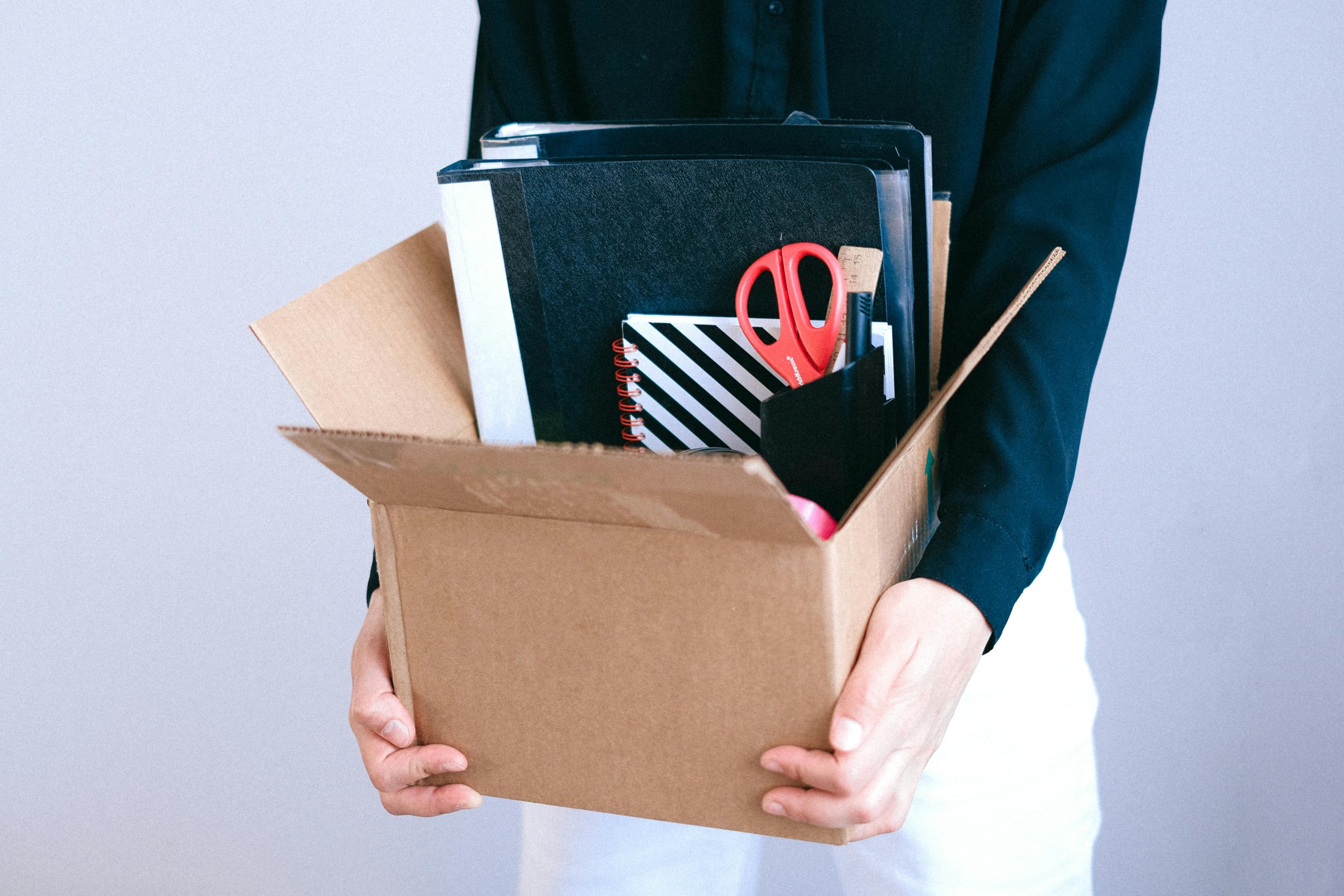 woman holding a box with office supplies