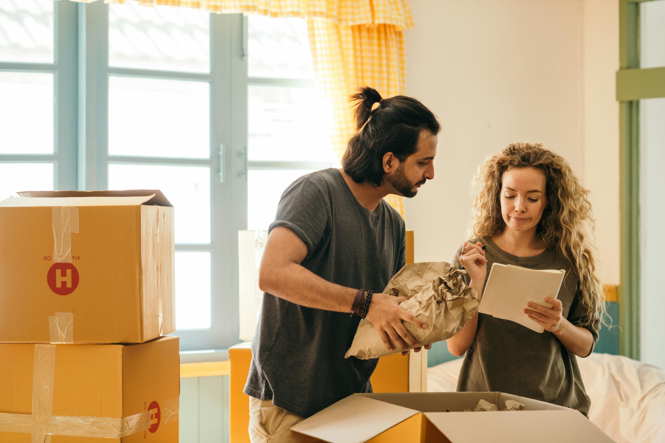 Couple packing up boxes and checking off a list for a move